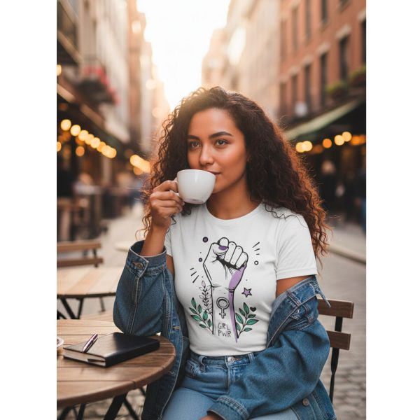 Mujer joven tomando café con la camiseta feminista GRL PWR de Ouh Rebel y chaqueta vaquera
