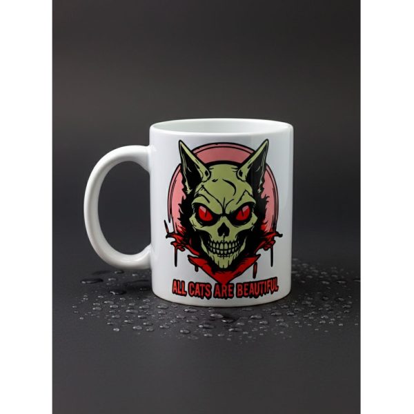 Taza blanca Ouh Rebel con diseño de gato calavera verde y frase All Cats Are Beautiful.