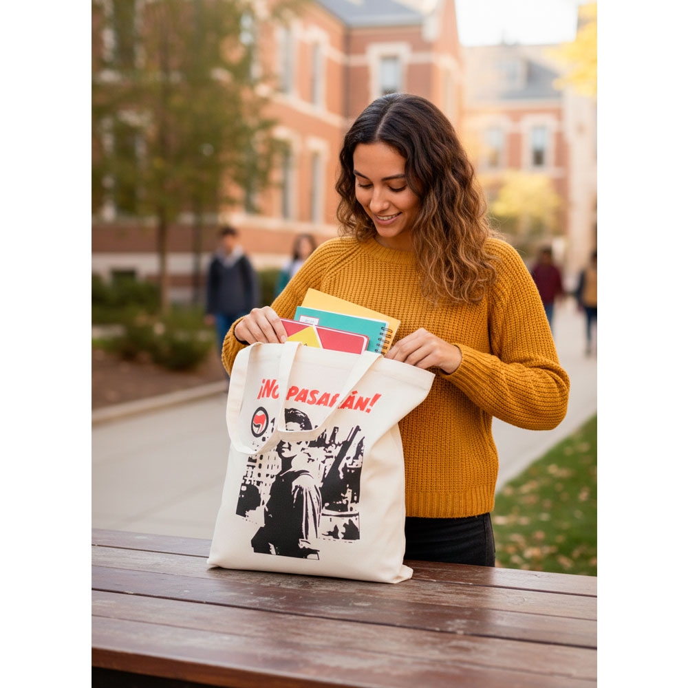 Mujer joven utilizando la tote bag No Pasarán para llevar libros y material de estudio.